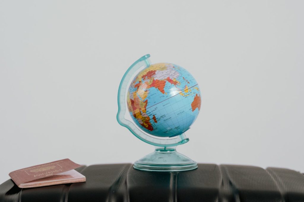 A globe and passport on a suitcase, symbolizing travel planning and wanderlust.
